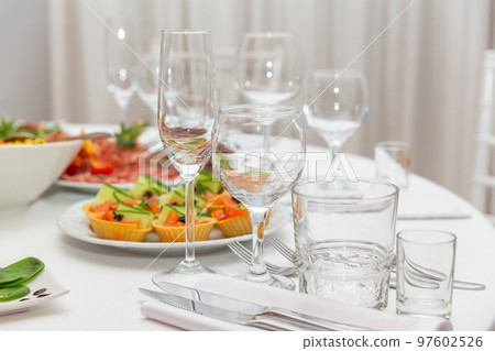 Served for holiday banquet restaurant table with dishes, snack, cutlery, wine and water glasses. 97602526