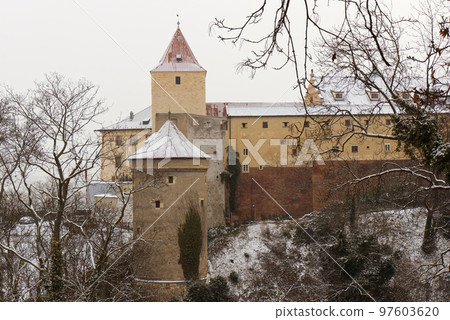 Deer Moat and Daliborka tower in foreground with snow-covered roofs of Prague Castle in winter, no people. Deer Moat and Daliborka tower in foreground with snow-covered roofs of Prague Castle in winter, no people. 97603620