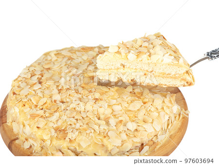 On a kitchen spatula, a slice of creamy Swedish almond cake topped with toasted almond flakes. On a kitchen spatula, a slice of creamy Swedish almond cake topped with toasted almond flakes. 97603694