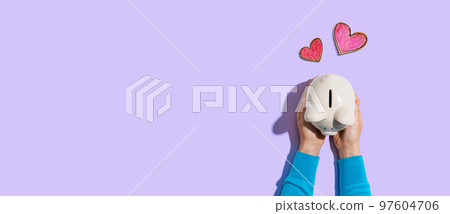 Person holding piggy bank with hearts 97604706