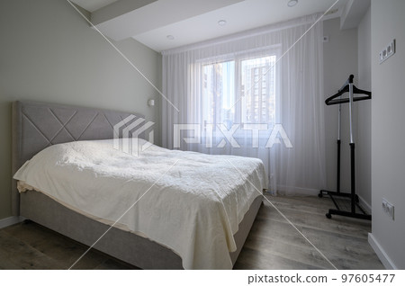 Interior of bright white bedroom with double bed Interior of bright white bedroom with double bed 97605477