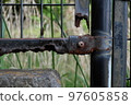 A rusted and crumbling iron fence 97605858