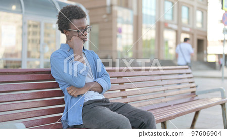 Tired Young African Man Sleeping while Sitting Outdoor on Bench Tired Young African Man Sleeping while Sitting Outdoor on Bench 97606904