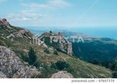 Large rock with green forest around. Large rock with green forest around. 97607379