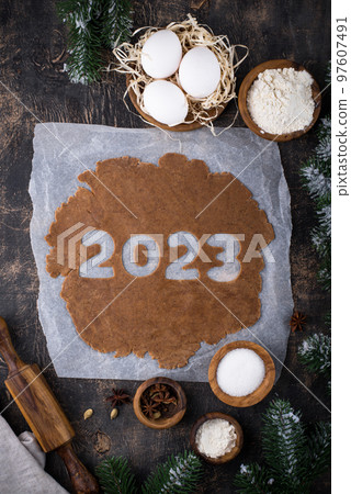 Gingerbread dough for cookies in shape of 2023 Gingerbread dough for cookies in shape of 2023 97607491