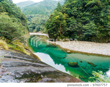 Scenery of Osugi Gorge (rock wall road and clear stream) 97607757