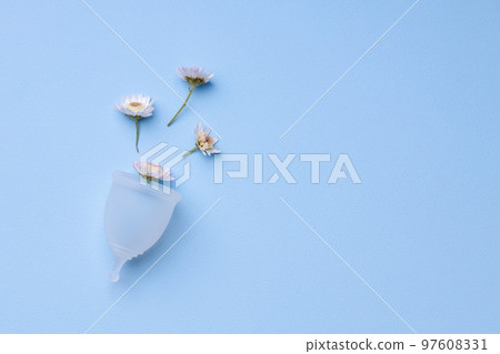 Menstrual cup with flowers on blue background Menstrual cup with flowers on blue background 97608331