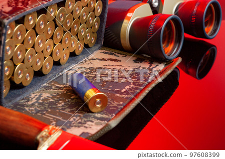 Shotgun cartridges in a cartridge bag in red light close up 97608399