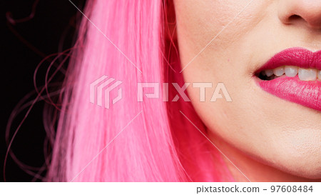 Beauty model with pink lipstick biting lips on camera, feeling sensual and attractive in studio. Confident carefree girl with beautiful mouth acting flirty and hot. Extreme closeup, macro shot. 97608484