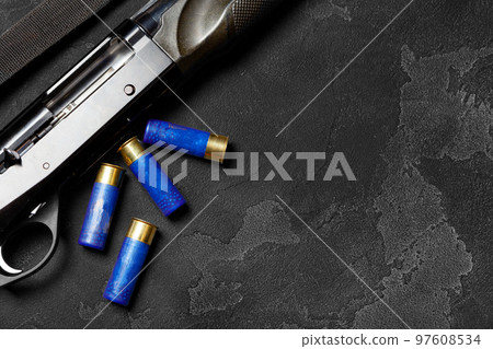 Close up of hunting shotgun and cartridges on dark grey background 97608534