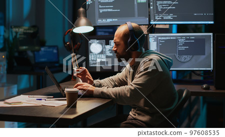 Funny programmer listening to music and playing air drums, fooling around in office. Young male coder having fun with instrument, acting silly and careless singing song on headset. 97608535