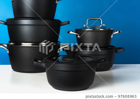 Set of black cookware against blue background 97608963