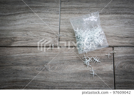 Laying ceramic tiles using plastic crosses. Packaging on the floor. Renovation or repair concept 97609042