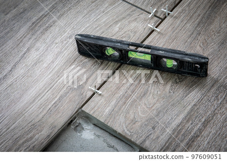 Black spirit level on tiles. Tiling works, renovation and construction 97609051