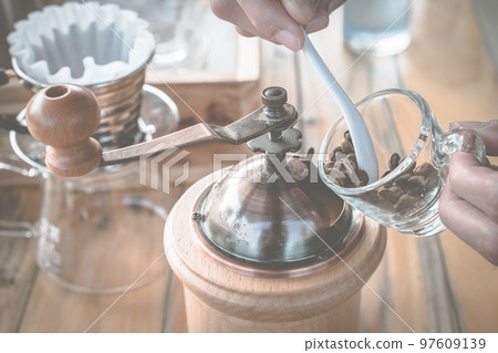 Barista prepare the coffee bean with hand coffee grinder for make drip coffee. Barista prepare the coffee bean with hand coffee grinder for make drip coffee. 97609139