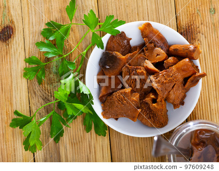 Chopped pickled mushrooms (Lactarius deliciosus) on board 97609248