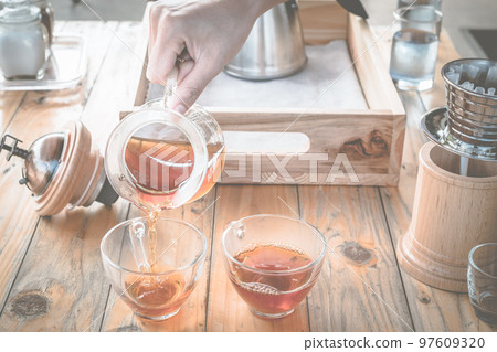 Barista pouring a hot coffee after dip coffee in a glass cup of coffee. 97609320