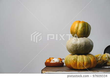 Pumpkins on kitchen table against grey wall Pumpkins on kitchen table against grey wall 97609334