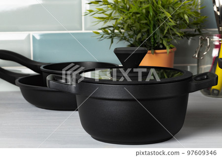 New black cookware against blue tile wall New black cookware against blue tile wall 97609346