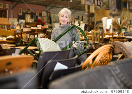Aged woman choosing chair in furniture shop Aged woman choosing chair in furniture shop 97609348
