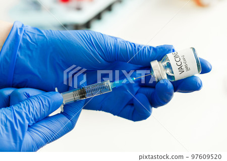 Doctor hands holding covid-19 vaccine preparing for vaccination of a patient 97609520