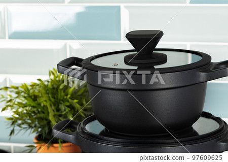 New black cookware against blue tile wall New black cookware against blue tile wall 97609625
