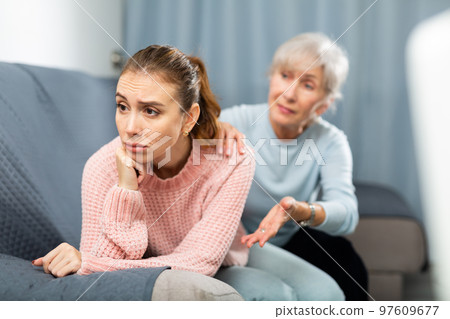 Mother encouraging her depressed adult daughter 97609677