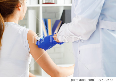 Doctor hands making a vaccination in the shoulder of patient Doctor hands making a vaccination in the shoulder of patient 97609678