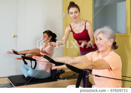 Portrait of a mature woman doing exercise on a simulator 97609731