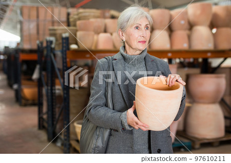 Elderly woman shopping in crockery store Elderly woman shopping in crockery store 97610211