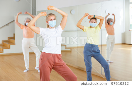 Women in masks dancing at lesson Women in masks dancing at lesson 97610212