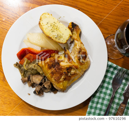 Closeup of baked chicken legs with mushrooms 97610296