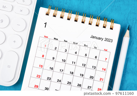 Close up the January 2023 Monthly desk calendar for 2023 year with calculator and wooden pencil. 97611160