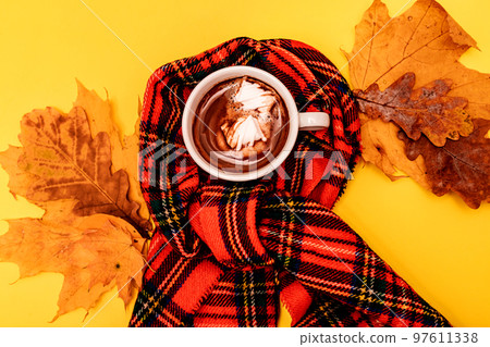 Autumn composition of a cup of coffee with marshmallow on a yellow background Autumn composition of a cup of coffee with marshmallow on a yellow background 97611338