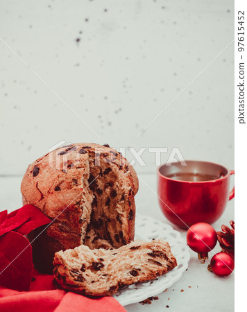 Panetonne with tea and a candle in the far right on a black concrete background Panetonne with tea and a candle in the far right on a black concrete background 97615452