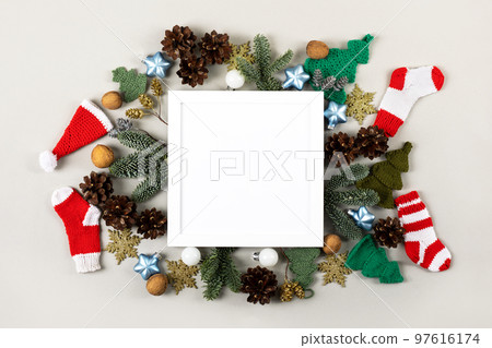 Creative Christmas composition with a white frame for text and congratulations on the New Year and Christmas. Red knitted socks, Santa Claus hat, Christmas tree branches, decorative ornaments Creative Christmas composition with a white frame for text and congratulations on the New Year and Christmas. Red knitted socks, Santa Claus hat, Christmas tree branches, decorative ornaments 97616174