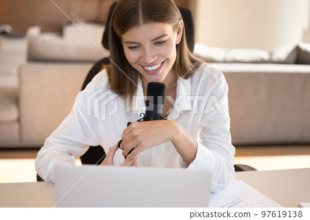 Happy pretty young blogger girl speaking at big professional microphone 97619138