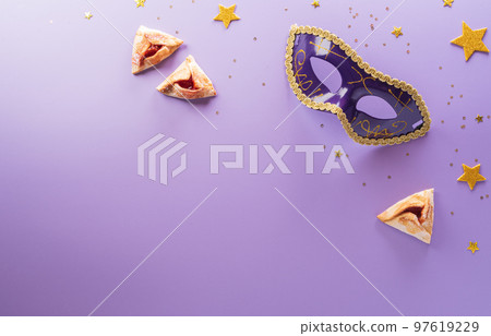 Happy Purim carnival decoration concept made from mask and sparkle star and hamantaschen cookies on pastel background. (Happy Purim in Hebrew, jewish holiday celebrate) 97619229