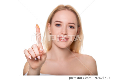 Focus on contact lens on finger of young woman. Young woman holding contact lens on finger in front of her face. Woman holding contact lens on white background. Focus on contact lens on finger of young woman. Young woman holding contact lens on finger in front of her face. Woman holding contact lens on white background. 97621397