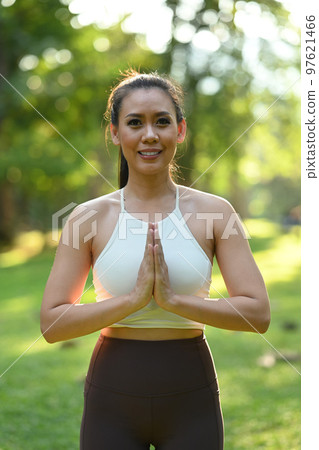 Pleasant millennial woman practice yoga outdoor in the morning during wellness retreat. Healthy lifestyle concept Pleasant millennial woman practice yoga outdoor in the morning during wellness retreat. Healthy lifestyle concept 97621466