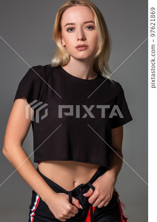 Beautiful blonde in a black t-shirt on grey background. Beautiful blonde in a black t-shirt on grey background. 97621869