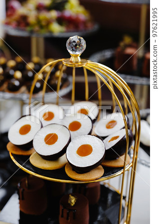 Many cakes standing among the candy bar. Sweet table. Banquet table. Holiday food and sweet festive table. 97621995