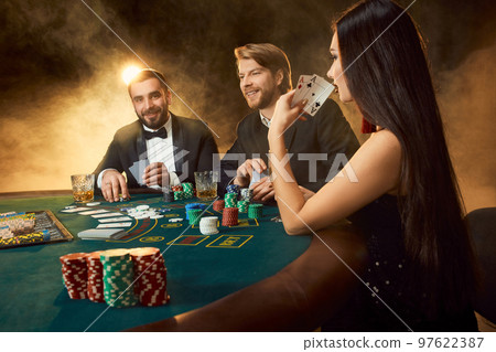 Group of young rich people is playing poker in the casino 97622387