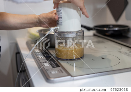 Senior woman's hand using food processor 97623018