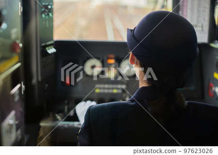 Rear view of a female train driver seen from the train window 97623026