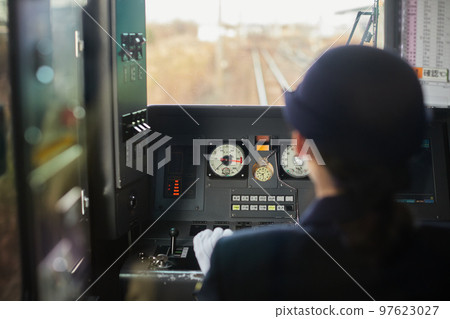 Rear view of a female train driver seen from the train window 97623027
