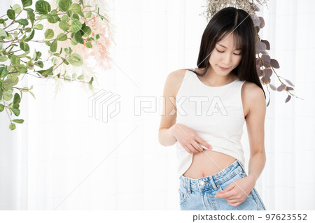 Young woman checking her waist Young woman checking her waist 97623552