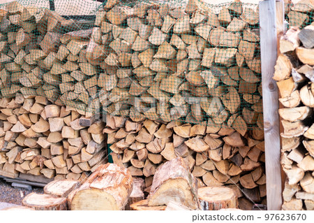 Stacked firewood for a wood stove and logs brought in 97623670