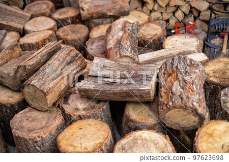 Stacked firewood for a wood stove and logs brought in 97623698