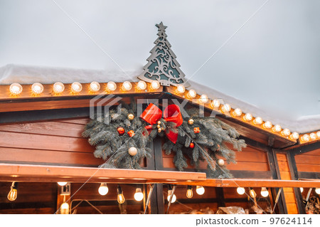 Garland decoration of stall at traditional Christmas fair. Retail store at Christmas in Katowice, Poland. Defocused Background, night city life backdrop 97624114